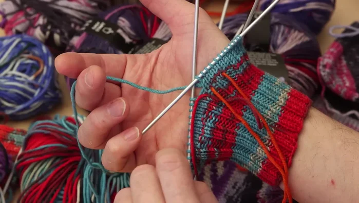 Increase stitches on either side of the marked thumb stitches until you have nine stitches for the thumb (adjust based on thumb size).