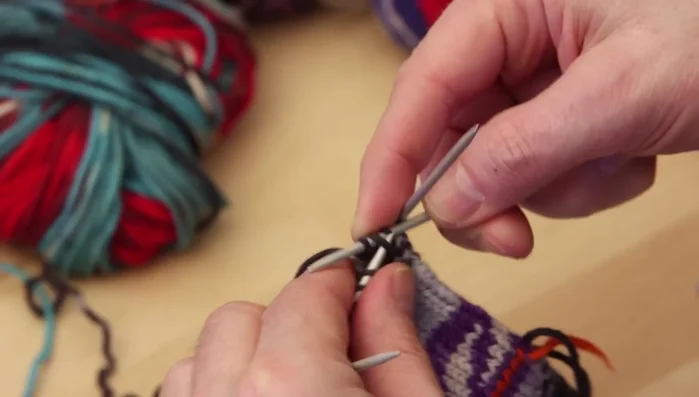 Decrease stitches on both sides of the mitten (palm and inside) on every second round until the top is closed. Knit one, slip one, knit one, pass slipped stitch over (or a similar decrease method).