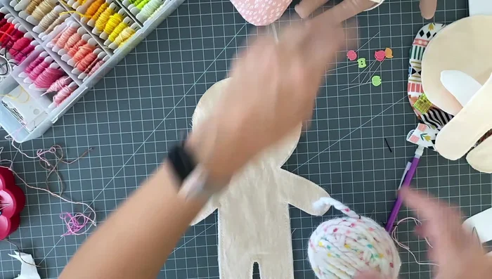 Prepare three loops of chunky yarn for the hair. Place them on the fabric, and baste them together.