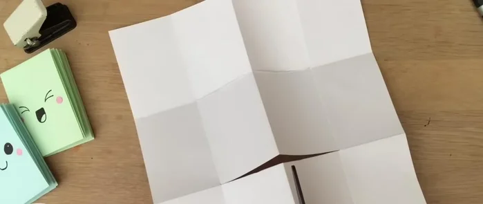 Open up the paper and cut along the center line of the two middle sections. (You can tear instead of cutting if your creases are sharp).