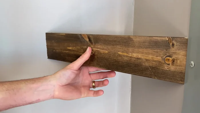 Secure the top trim piece with brad nails, ensuring they go into the wall mounts.