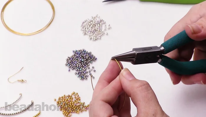 Cut the excess wire using memory wire cutters. Ensure you leave enough wire for another loop.