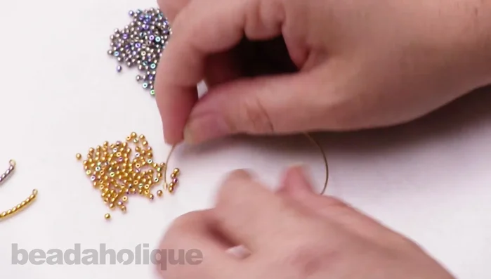 Cut the excess wire using memory wire cutters. Ensure you leave enough wire for another loop.