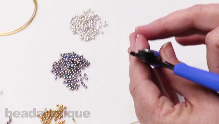 Cut the excess wire using memory wire cutters. Ensure you leave enough wire for another loop.