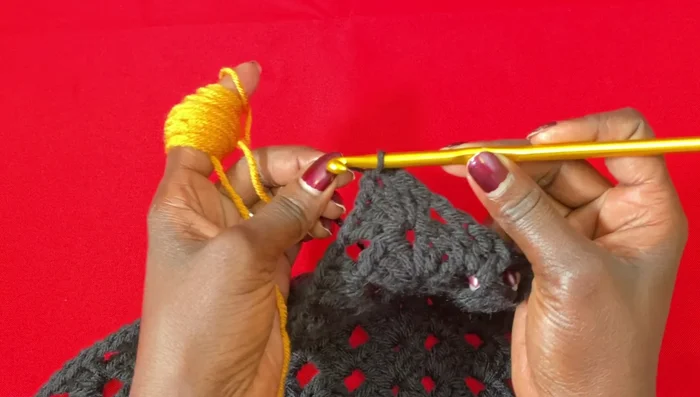 Continue working granny stitches with the new color (10 rows of orange/curry in this example).