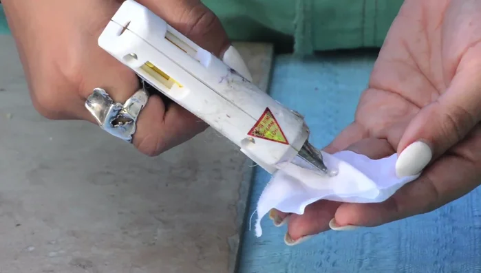 Create flower buds: Apply hot glue to the center of each square and fold to create a bud. Make many buds.