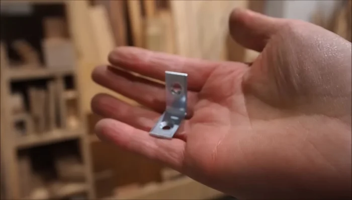 Attach metal corner braces (painted black) to join the wall panels, ensuring panels are pushed together to close gaps.