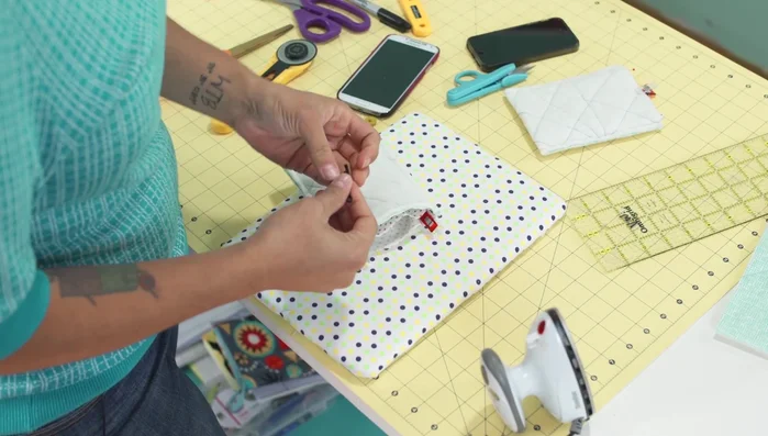 Attach elastic closure: Place the 4-inch elastic piece between the lining and outer fabric. Stitch all three layers together around the top edge. A technique of stitching from the inside is recommended for easier handling.