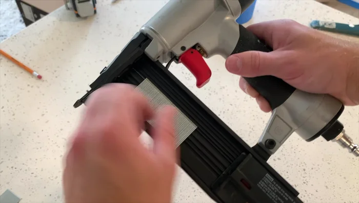 Attach the top rail to the wall using construction adhesive and brad nails, securing it to wall studs where possible.