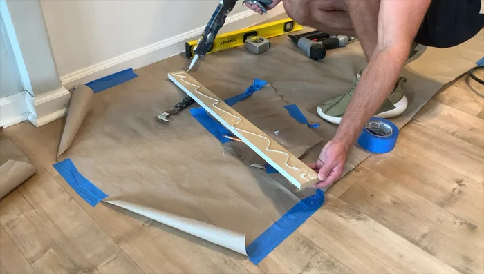 Install vertical boards using construction adhesive and brad nails, ensuring they are plumb.