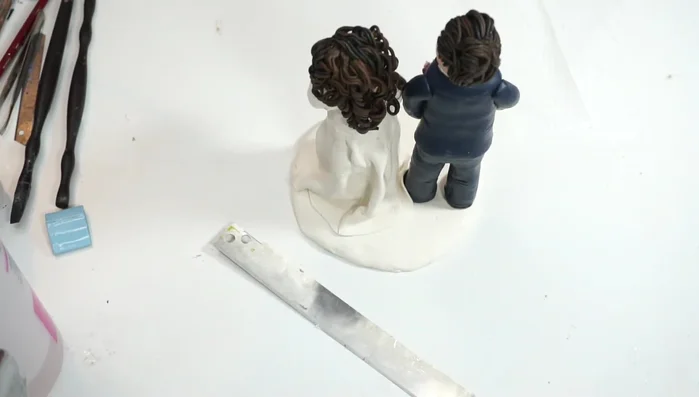 Add finishing touches: veil, tiara, and facial features using acrylic paint.