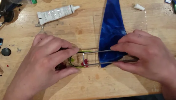 Carefully place the fused glass tomato piece onto the glue. Press gently to secure it. Add additional glue around the edges to ensure a secure bond.