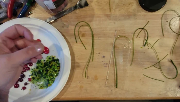 Apply a small amount of glue to the tops of the glass tomatoes and add a small amount of green frit to represent leaves.