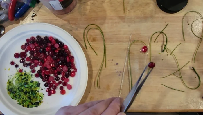 Apply a small amount of glue to the tops of the glass tomatoes and add a small amount of green frit to represent leaves.
