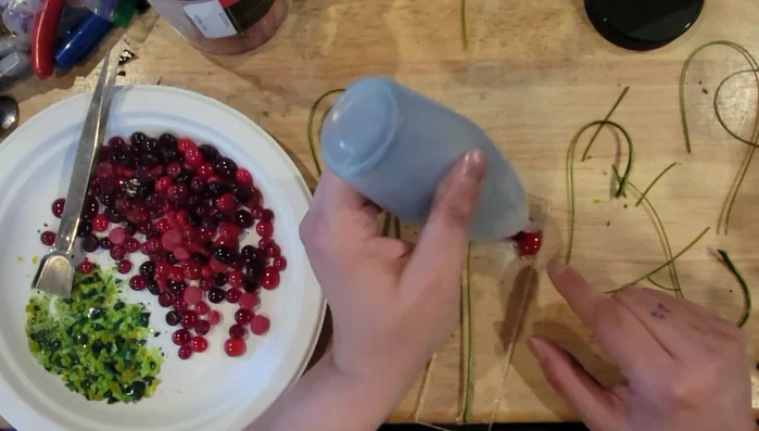 Apply a small amount of glue to the tops of the glass tomatoes and add a small amount of green frit to represent leaves.