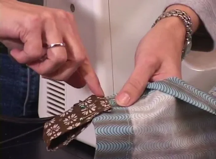 Sew a line along the bottom edge of the tab to secure it and ensure it hangs flat.