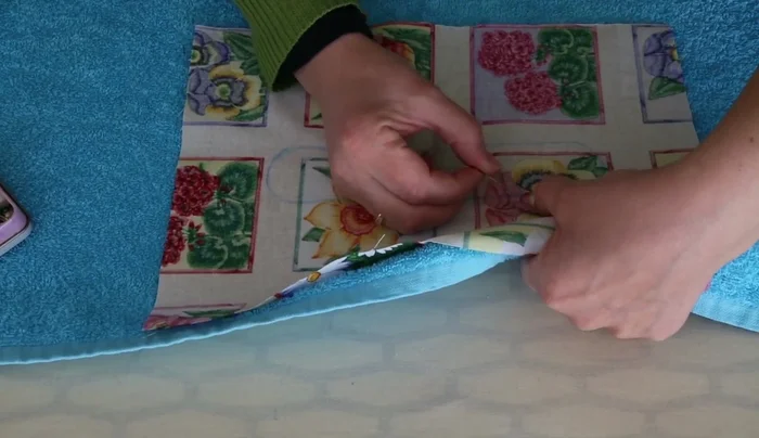 Pin the fabric to the towel and stitch around the traced line.