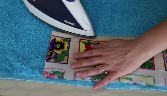 Fold the seam allowance inward and stitch it down, securing the raw edges.