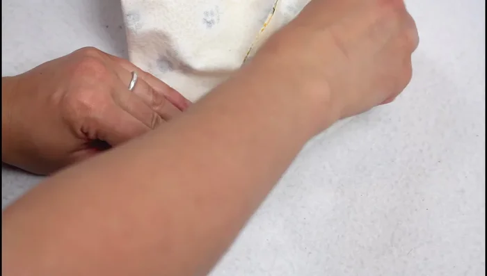 Box the corners: Flatten corners to form a V-shape, ensuring seam allowances go in opposite directions. Use an acrylic roller to mark a 4-inch line from the corner along the side. Trim excess fabric leaving a 1/2 inch seam allowance.