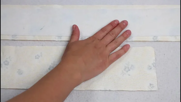 Prepare straps: Fuse stabilizer to the back of each strap piece using an iron. Fold over the edges toward the inside, using the stabilizer as a guide. Fold the entire strap in half and press.