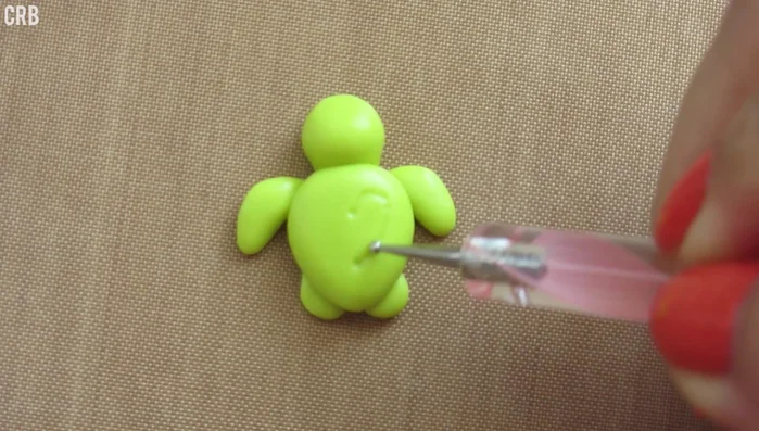 Using a dotting tool, create a heart pattern on the shell by making indents.