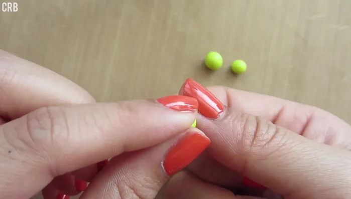 Roll and shape the second-largest ball into a neck and head, attaching it to the shell.