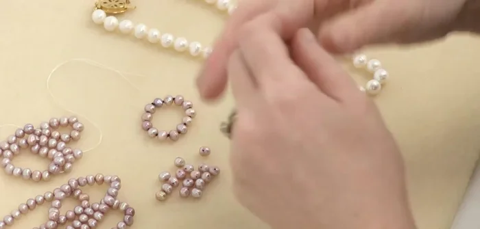 String on the first bead: Thread the needle through the chosen bead and pass it through a second time to ensure you can pass through twice. Slide it down to the tape.