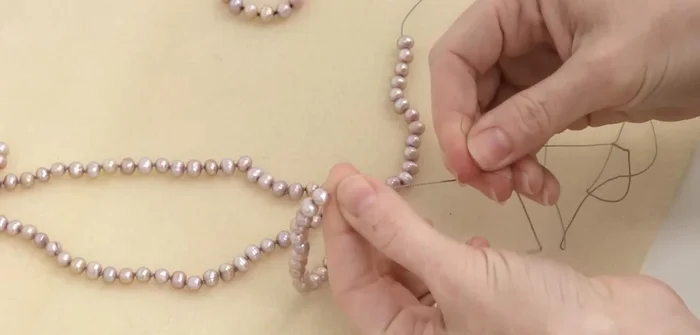 Create the final knot: Cross the two silk ends and make a knot between the last three beads (including the first bead).