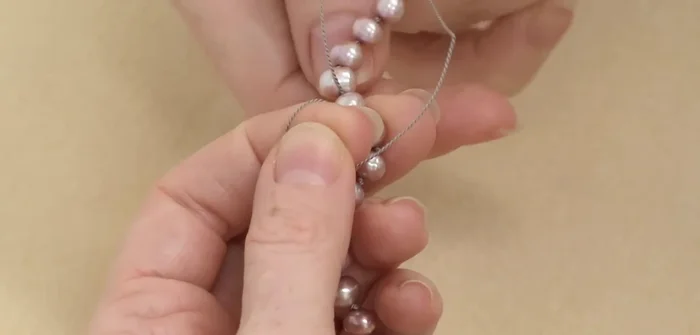 Create the final knot: Cross the two silk ends and make a knot between the last three beads (including the first bead).