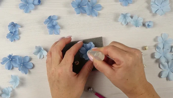 Add stamens or buttons to the center of the flower.