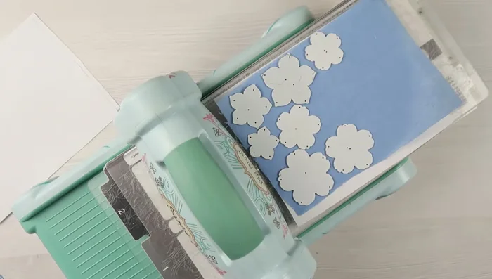 Die-cut the fabric flowers using scrap paper underneath for a crisp cut.