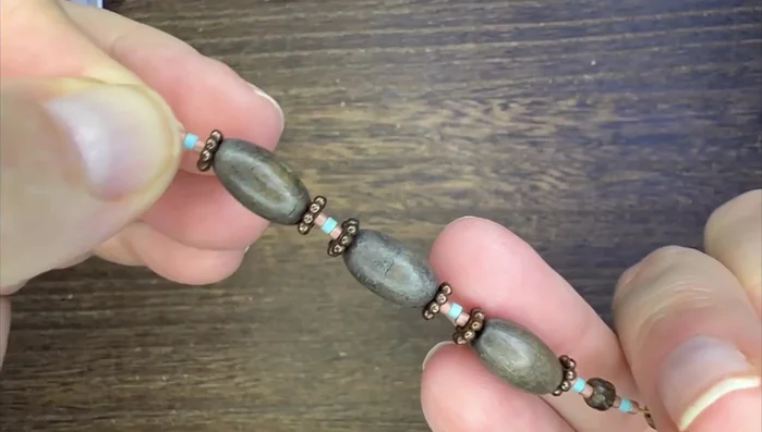 Use daisy spacers to close the large holes in the oval tube wood beads.