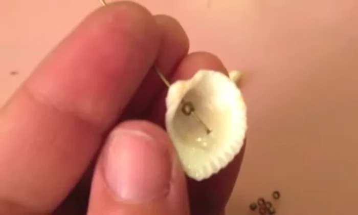 Attach the earring hook: Slip an earring hook into the loop and use pliers to tuck the wire end into the top bead.