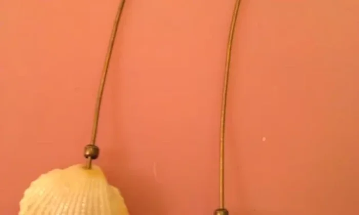 Attach the earring hook: Slip an earring hook into the loop and use pliers to tuck the wire end into the top bead.