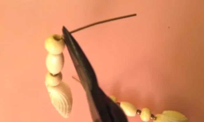 Attach the earring hook: Slip an earring hook into the loop and use pliers to tuck the wire end into the top bead.