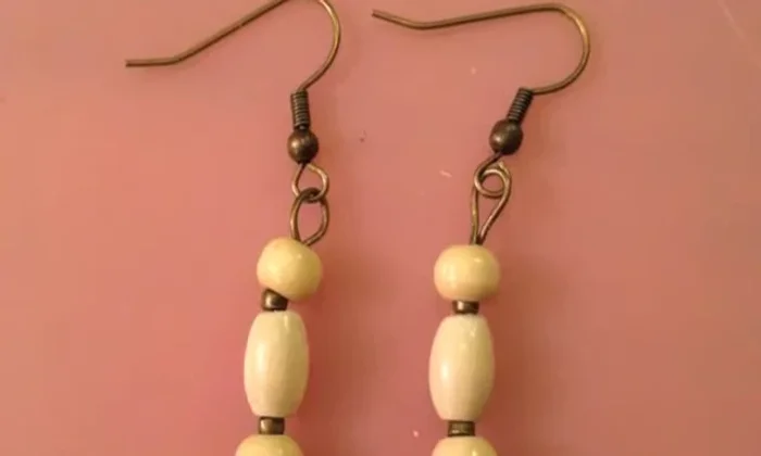 Attach the earring hook: Slip an earring hook into the loop and use pliers to tuck the wire end into the top bead.