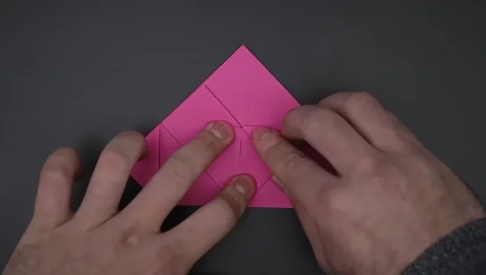 Bring down the top triangles, unfold, and flatten to create flaps.