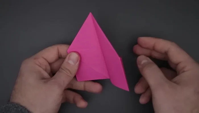 Close the front and back sides. Fold the squares in half diagonally, then fold the remaining corner up. Repeat on the other side.