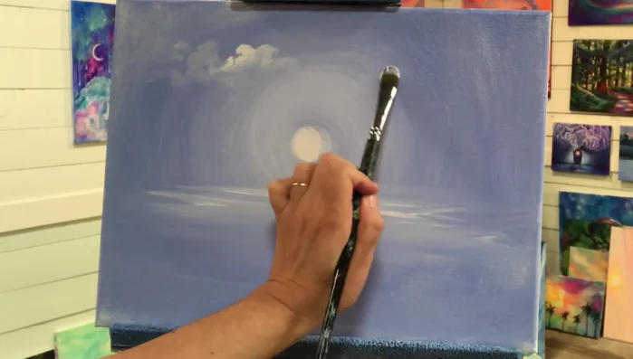 Create soft clouds. Use a filbert brush flat on the canvas, tapping, pushing, and gently smudging titanium white to create soft, puffy clouds.