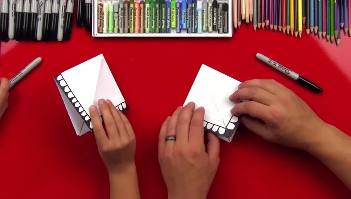 Fold the top layer of each triangle up to the top, creasing well, and repeat on the other side.