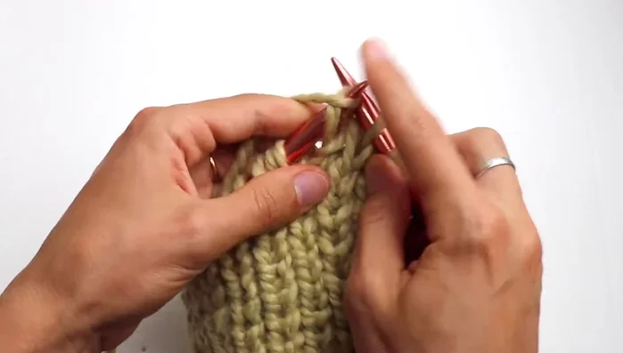Continue knitting in pattern until the hat reaches approximately 23-24 centimeters. 