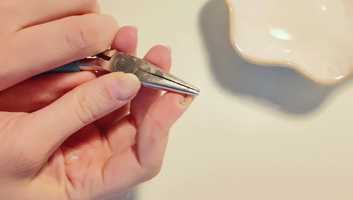 Cut and bend eye pin to appropriate length. Insert carefully into the charm.