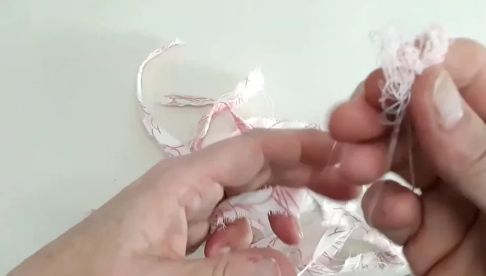 Make a hole at each end of fabric strips by layering, folding, and cutting a slit.