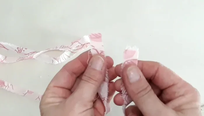 Make a hole at each end of fabric strips by layering, folding, and cutting a slit.