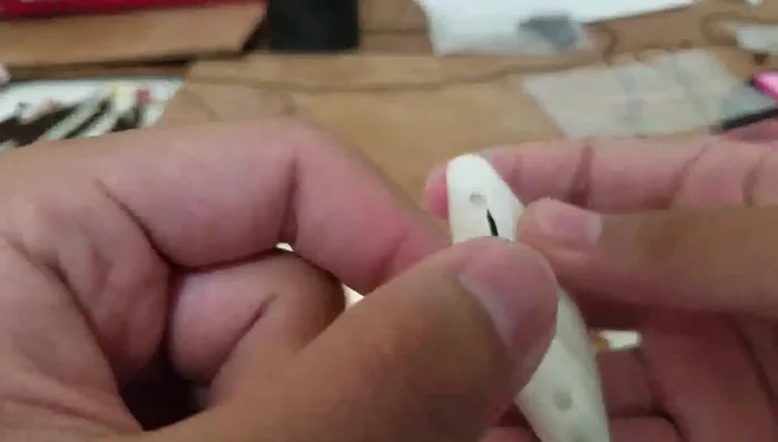 Tie a triple knot (or double knot) on the rope, securing it to the necklace.