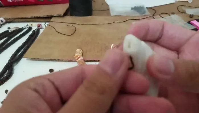 Tie a triple knot (or double knot) on the rope, securing it to the necklace.