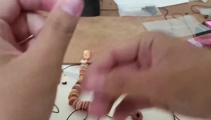 Add beads to the rope, ensuring they are evenly spaced. The video shows a 'face down' method where all beads face the same direction.