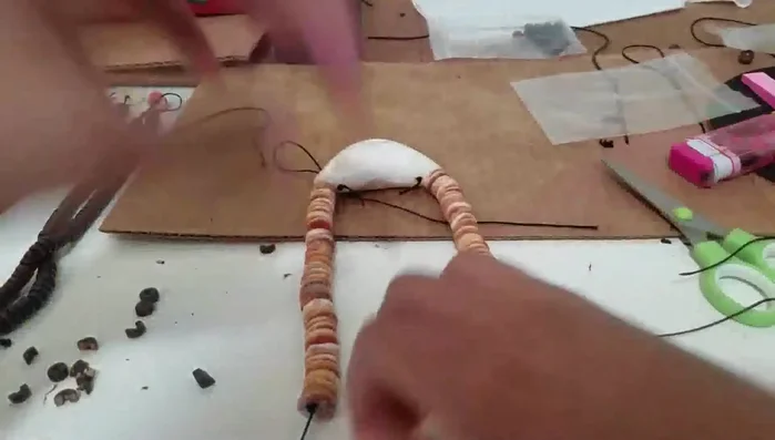 Tie the clasp onto one end and make an overhand loop on the other end to create equal lengths on both sides.