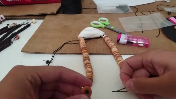 Prepare your materials: Sonata necklace, rope (cut in half and ends burned), lighter, and scissors.