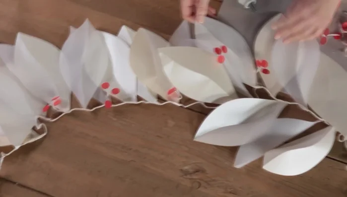 Attach the berry clusters to the backs of every third or fourth leaf on the garland using hot glue.
